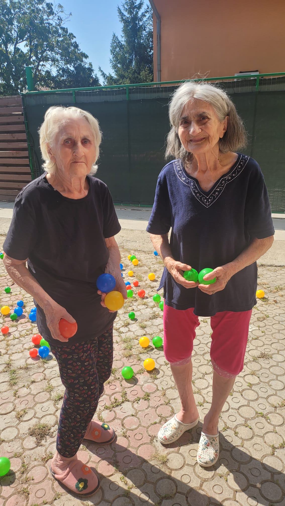 Persoane vârstnice fericite în grădina căminului